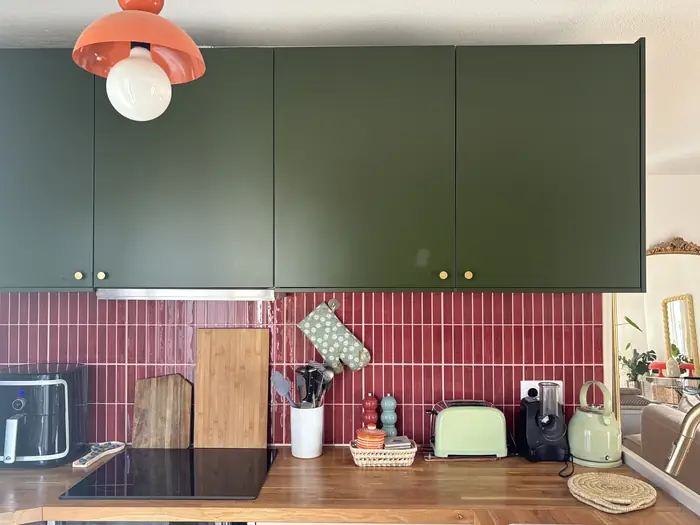 Cuisine équipée aux placards vert olive et crédence carrelée
